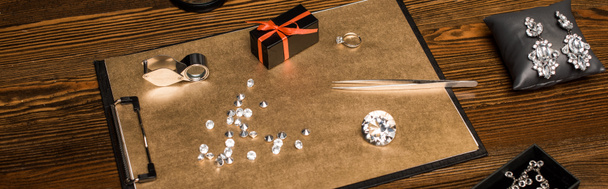 Panoráma felvétel drágakövekről, ékszerekről és ajándékdobozokról a fa asztalon  - Fotó, kép
