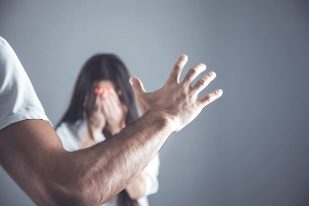 angry man beat sad woman on darkbackground - Valokuva, kuva
