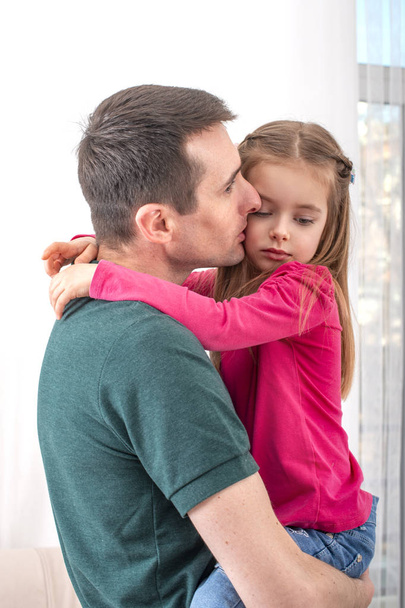 Un joven con una hija pequeña pasa tiempo en casa. El papel moderno de los hombres en la familia
.  - Foto, Imagen