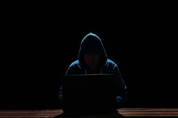 hacker with laptop on black background - Фото, изображение