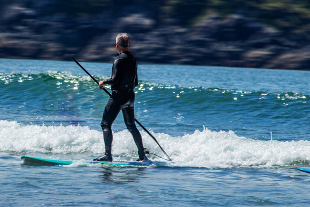 Szörfös figyeli és navigál a hullámok - Tofino, Vancouver Island, BC, Kanada - Fotó, kép