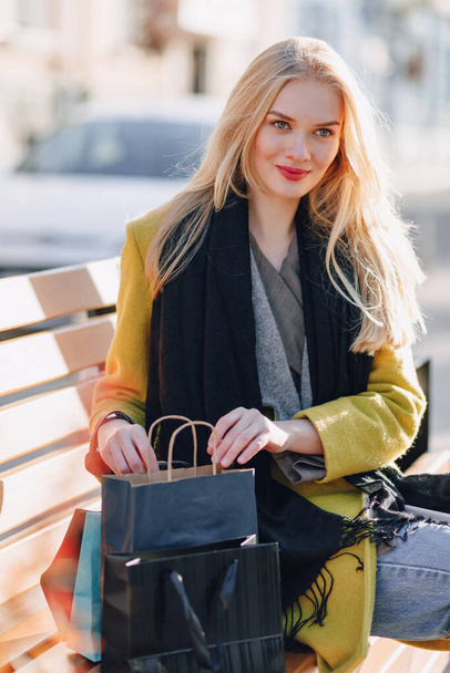 cute happy attractive blonde woman with packages on the street in sunny warm weather. shopping and positive emotions. - Photo, Image