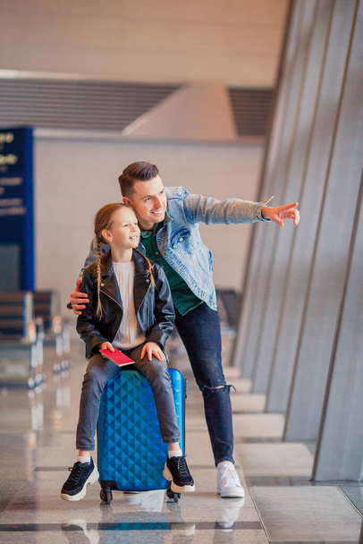 Família feliz com bagagem e cartão de embarque no aeroporto à espera de embarque
 - Foto, Imagem