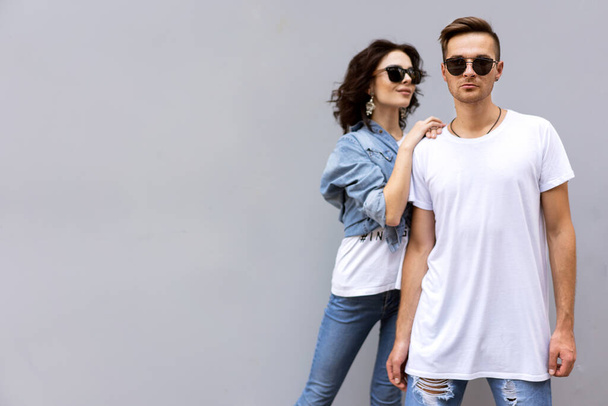 fashion couple posing on a gray background in the street - 写真・画像