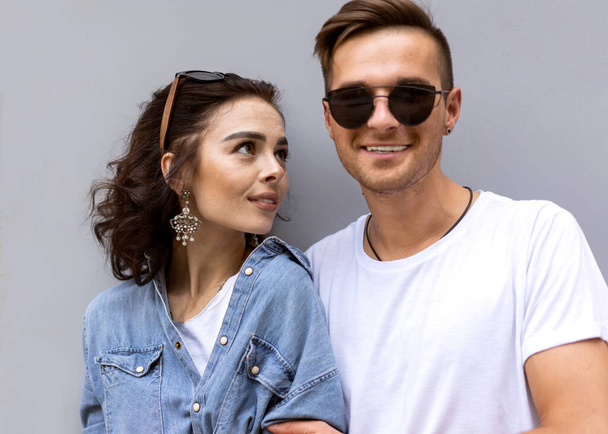 fashion couple posing on a gray background in the street - Photo, image