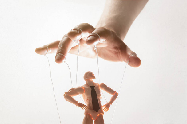 Concept of control. Marionette in human hand. Image on white. - Photo, Image