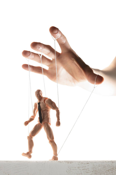 Concept of control. Marionette in human hand. Image on white. - Photo, Image