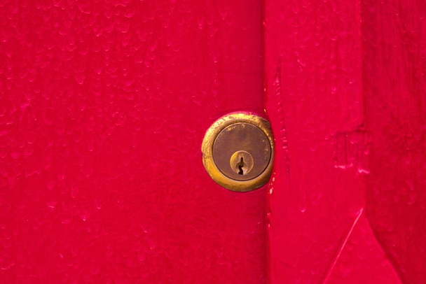 Messinki lukko veren punainen maalattu puinen ovi. Sulje se. Turvallisuus, turvaaminen ja säilytys
. - Valokuva, kuva