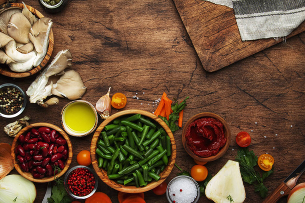 Food cooking background, ingredients for preparation vegan dishes, vegetables, roots, spices, mushrooms and herbs.  Healthy food concept. Rustic wooden table. Top view - Foto, imagen