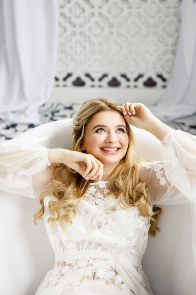 portrait of a young beautiful blonde bride in a beautiful dress in the bathroom - Photo, Image