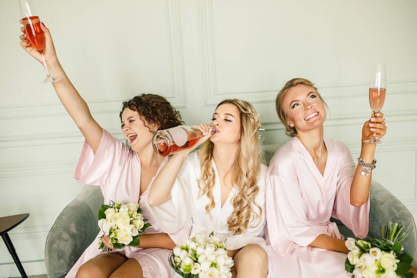 young beautiful blonde wedding bride in beautiful white dress having fun with bridesmaids - Valokuva, kuva