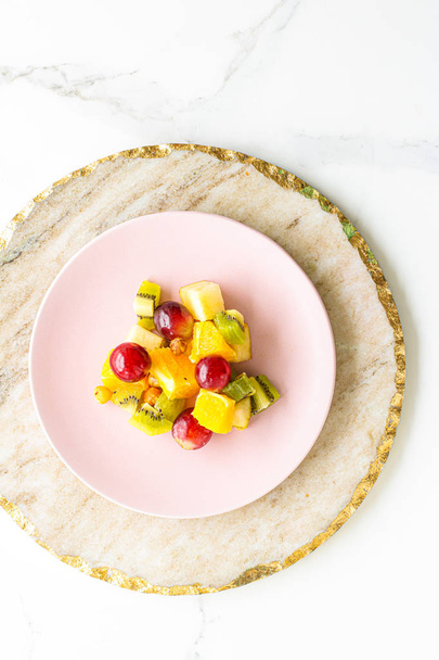 Ruoka, juomat ja ruokavalio konsepti - Tuoreet hedelmät vegaanisalaatti vaaleanpunaisella lautasella, terveellinen ravitsemus ja detox
 - Valokuva, kuva