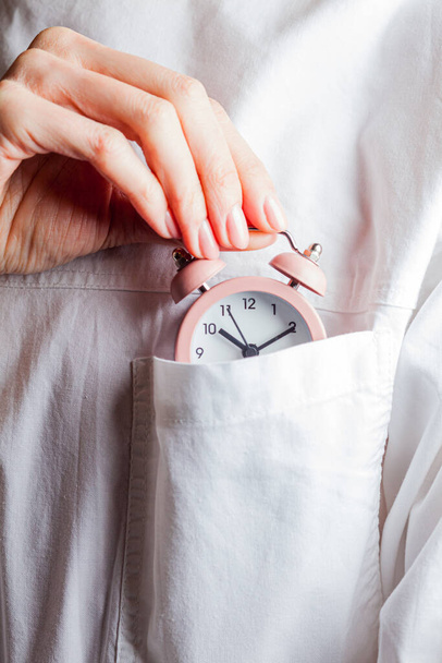 Woman with alarm clock spends time carefully - Foto, Imagen