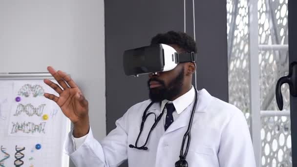 Portrait of Afro american scientist using and testing virtual reality glasses while working in hospital office room. Dolly shot - Кадры, видео