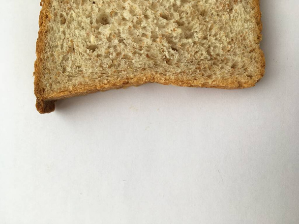 Egy szelet fehér kenyér, fehér alapon. Minimalista háttér. - Fotó, kép