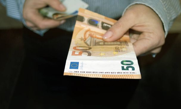 La main d'une femme donne de l'argent. Euro dans les mains des femmes
. - Photo, image