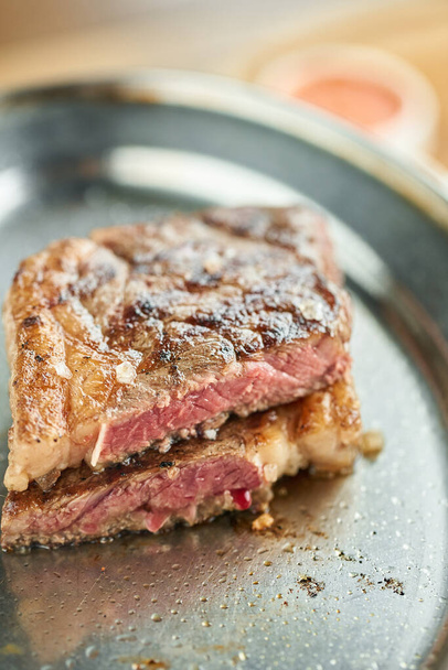 tányér Grillezett sztriptíz steak. A sztriptíz steak, más néven New York-i csík. Fából készült deszkán szolgáltam. Grill étterem menü. - Fotó, kép
