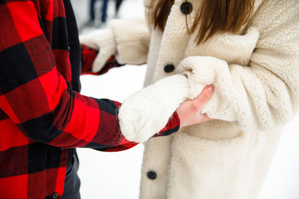 boy hands holding girl on winter ice ring background - Fotó, kép