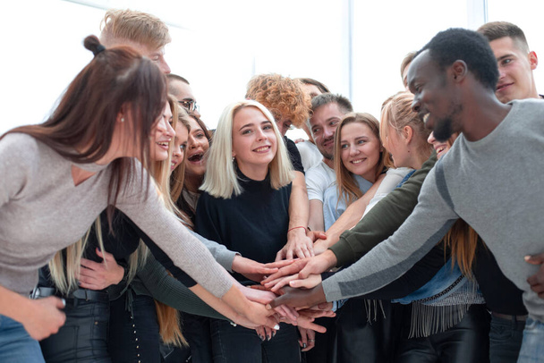 Разнообразные молодые люди поднимают руки вместе - Фото, изображение