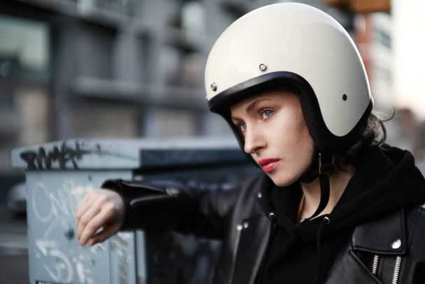 Close-up portret van biker meisje poseren buiten en het dragen van een zonnebril en witte helm. - Foto, afbeelding