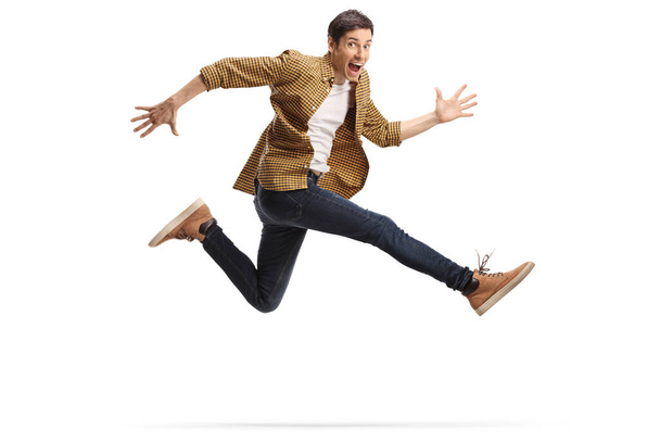 Casual happy young man jumping isolated on white background - Foto, afbeelding