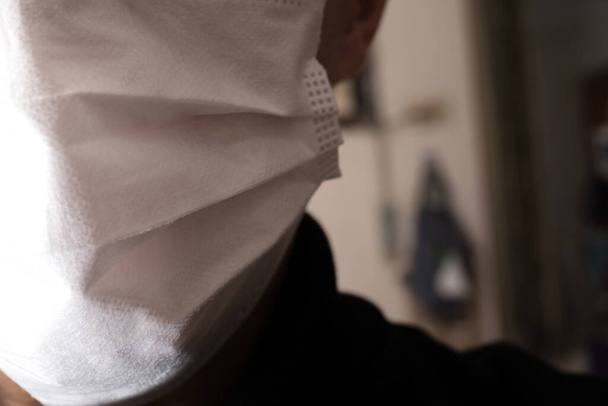 Fechar com o rosto de um jovem vestindo máscara médica ou cirúrgica
 - Foto, Imagem