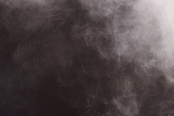 Sűrű bolyhos puffanások fehér füst és köd a fekete háttér, elvont füst felhők, minden mozgás elmosódott, szándék a fókusz, és a magas alacsony expozíció kontraszt, másolás helyet szöveges logó - Fotó, kép