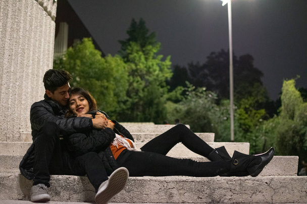 Молодая влюбленная пара хорошо провела ночь, сидя на лестнице и разговаривая
 - Фото, изображение