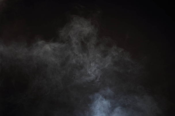 Gęste puszyste puszki białego dymu i mgły na czarnym tle, Abstrakcyjne chmury dymne, zamazane ruchy, nieostre intencje i wysoki kontrast niskiej ekspozycji, przestrzeń na kopiowanie logo tekstu - Zdjęcie, obraz
