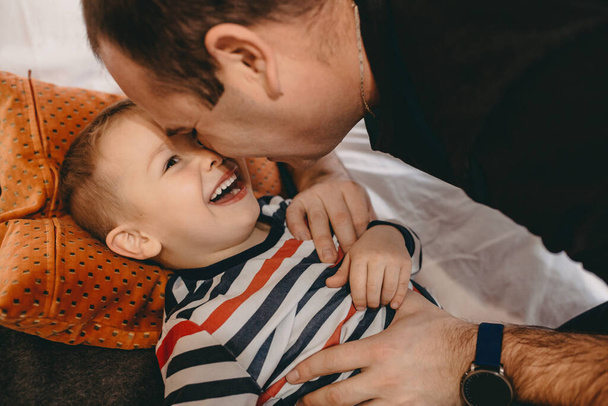 Close up retrato de um pai caucasiano brincando com seu filho em um sofá durante um dia de fim de semana
 - Foto, Imagem