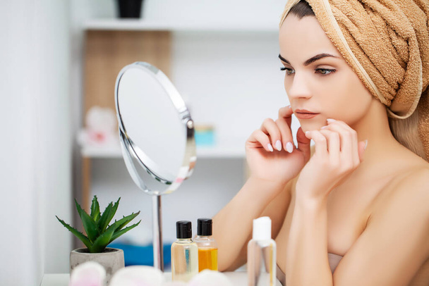 Femme se préparer pour le travail faisant maquillage le matin dans le miroir de salle de bain à la maison
. - Photo, image