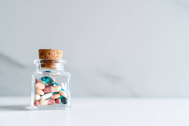 Вид сверху на лекарственные тарелки льют из таблеток бутылки мраморной текстуры на белом фоне. Тенденция развития медицинского образа жизни
. - Фото, изображение