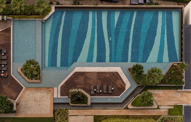 Bangkok, Thajsko - 27.2.2020: Pohled shora na venkovní koupaliště Bazén obklopující palmy a zelenou zahradu v krásném bytě. Moderní krajinná architektura s bazénem. - Fotografie, Obrázek