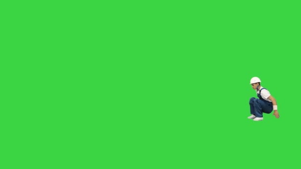 Construction worker making flips and rolls passing by the camera on a Green Screen, Chroma Key. - Materiał filmowy, wideo