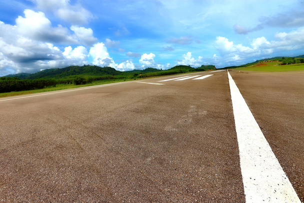 Airport Runway Taxi with white line, green mountain and blue sky with clouds, copy space - Photo, Image