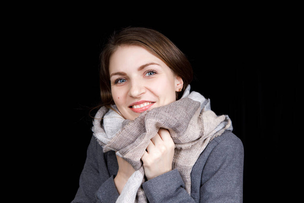 Девушка завернута в серый шарф. Портрет крупного плана
 - Фото, изображение