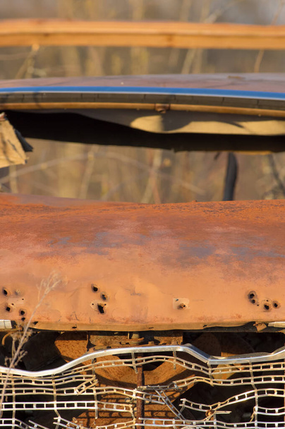 Antiguo vintage oxidado coches faros y zona de parrilla izquierda en el medio de la nada donde el campo forestal en Wisconsin rural con luz dorada al atardecer
 - Foto, imagen