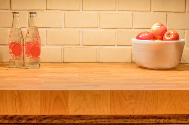 Jabłka w misce z wodą butelkowaną na pięknym drewnianym stole do cięcia deski z unikalnym oświetleniem szafy z góry - miejsce na tekst, jak również - Zdjęcie, obraz