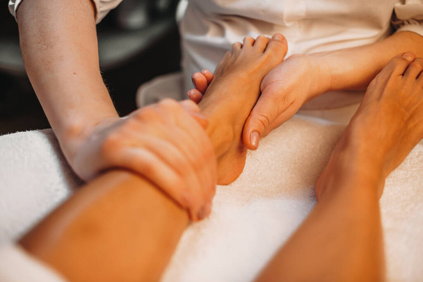 Médico caucásico teniendo una sesión para los clientes piernas piel masajeándolos bien
 - Foto, Imagen