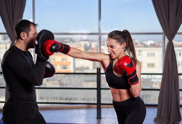 Young boxer woman hitting mitts with her coach - Fotoğraf, Görsel