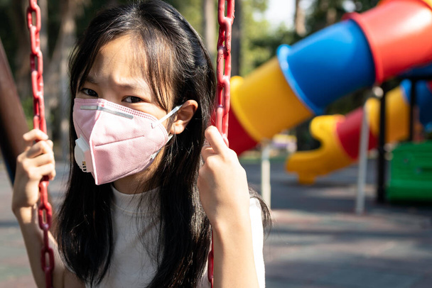 Védőmaszkot viselő ázsiai gyermek lány, mérgező szmog, finom por, légszennyezés, Pm2.5, Bangkok a légszennyezésben, veszély a légzőrendszerre, asztma kockázata, krónikus bronchitis, tüdőrák - Fotó, kép