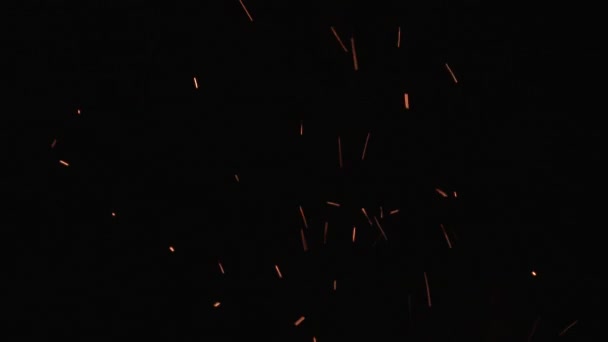 Égő hamu emelkedik a tűz az éjszakai égbolton, mérsékelt mennyiségű szikra a háttérben. - Felvétel, videó