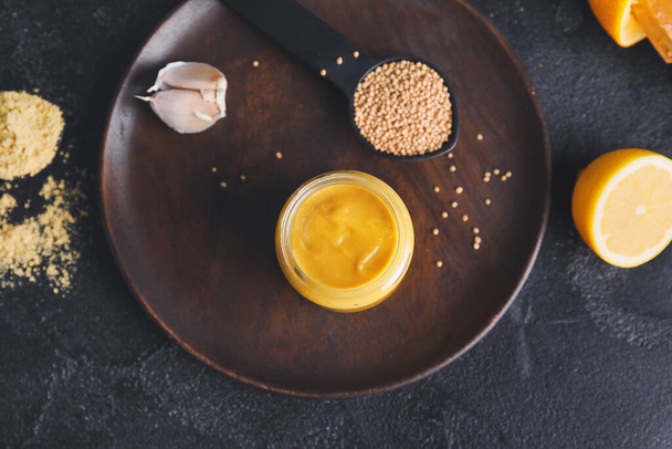 Tarro de sabrosa salsa de mostaza miel sobre fondo oscuro
 - Foto, Imagen