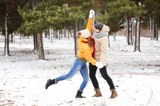 Happy young couple dancing in park on winter day - Photo, Image