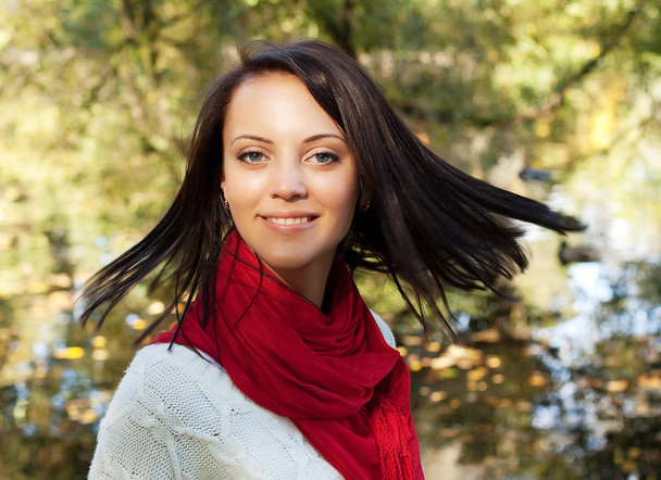 Happy woman near the river in autumn season - Photo, Image