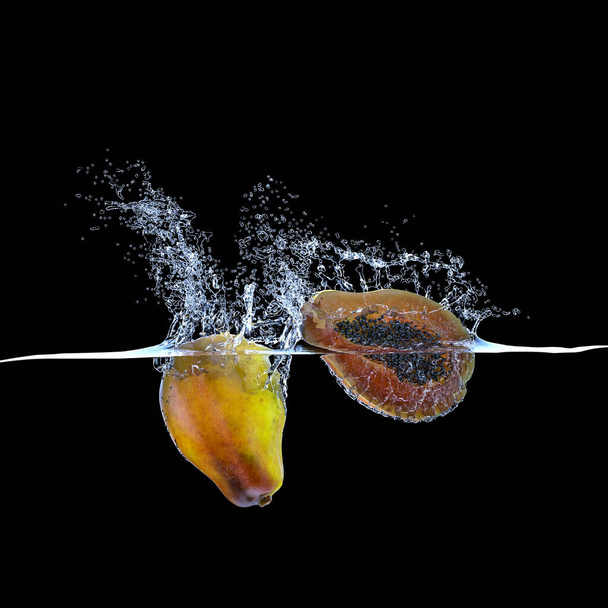 papaya fruit that falls into water and creates splashes. black background nobody around. concept of freshness and natural food. 3d render. - Fotó, kép
