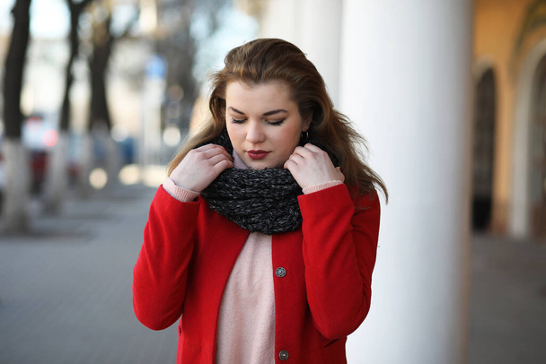 Pretty girl on a walk in a red coat in the city - Foto, imagen