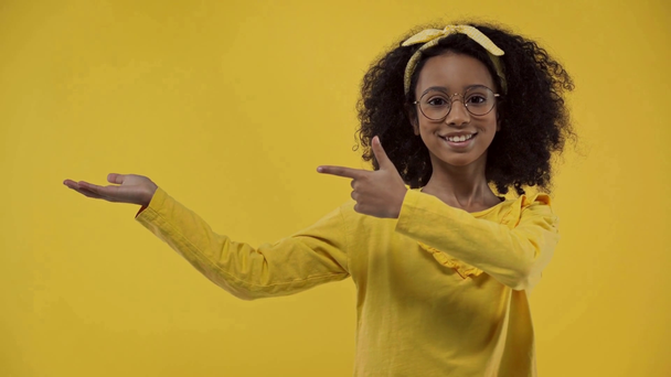 lindo africano americano niño apuntando con dedo aislado en amarillo
  - Imágenes, Vídeo