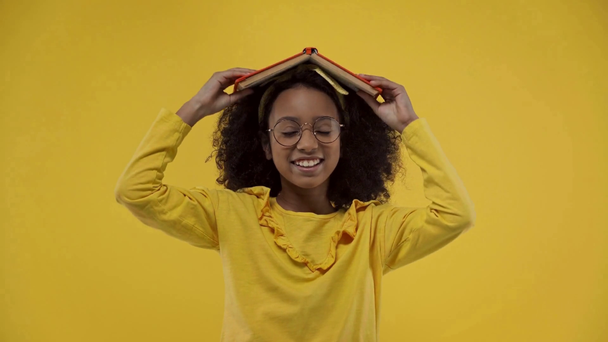 africano americano niño gesto y celebración libro aislado en amarillo
  - Imágenes, Vídeo