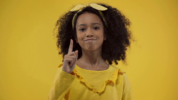 Αφροαμερικανό παιδί που δεν δείχνει κανένα σημάδι απομονωμένο στο κίτρινο  - Πλάνα, βίντεο
